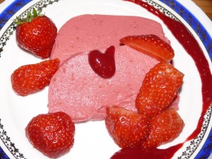 Die fertige Himbeer-Rhabarber-Terrine mit frischen Erdbeeren und Himbeerpuree