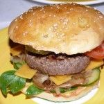 Cheeseburger mit selbst gebackenem Brötchen. SO muß das aussehen! (150 g frisch gewolftes Bio-Rind, belegt mit Feldsalat, frischen Röstzwiebeln, Cheddar, Tomaten, Gurken, Essiggurken, Ketchup, Senf und frisch aufgeschlagener Aioli)