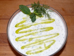 Cacik mit Olivenöl, Dill und Minze angerichtet.